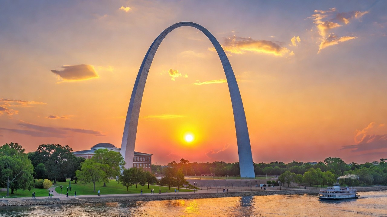 Gateway Arch curving above the Mississippi River at sunset, St. Louis