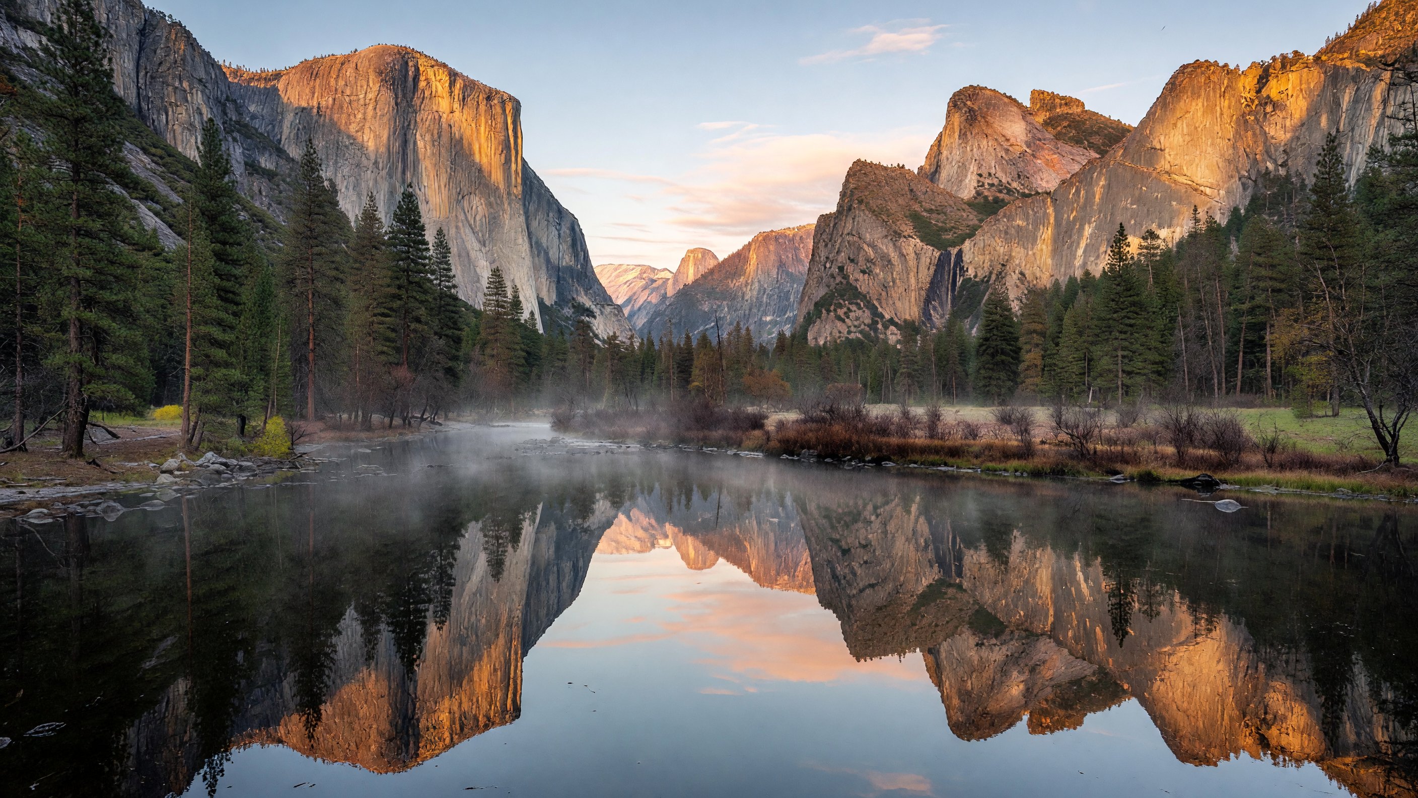 Yosemite Valley at sunrise with El Capitan and Half Dome reflected in the Merced River, golden light on granite walls